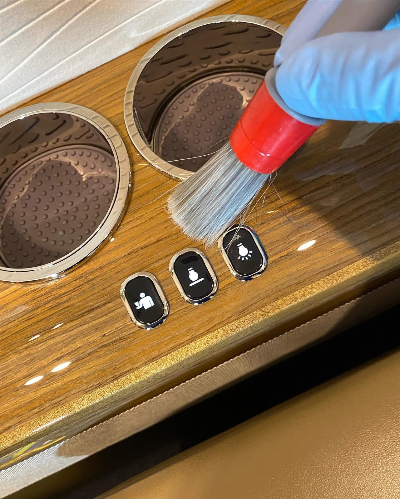 Detail brush cleaning cabin cupholders and wood veneer