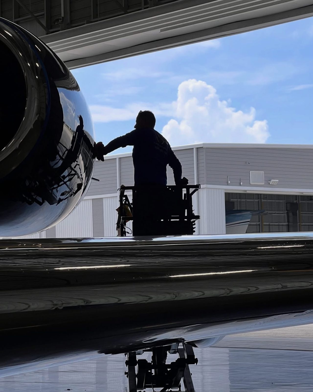 Avioera technician washing a business jet on the ramp